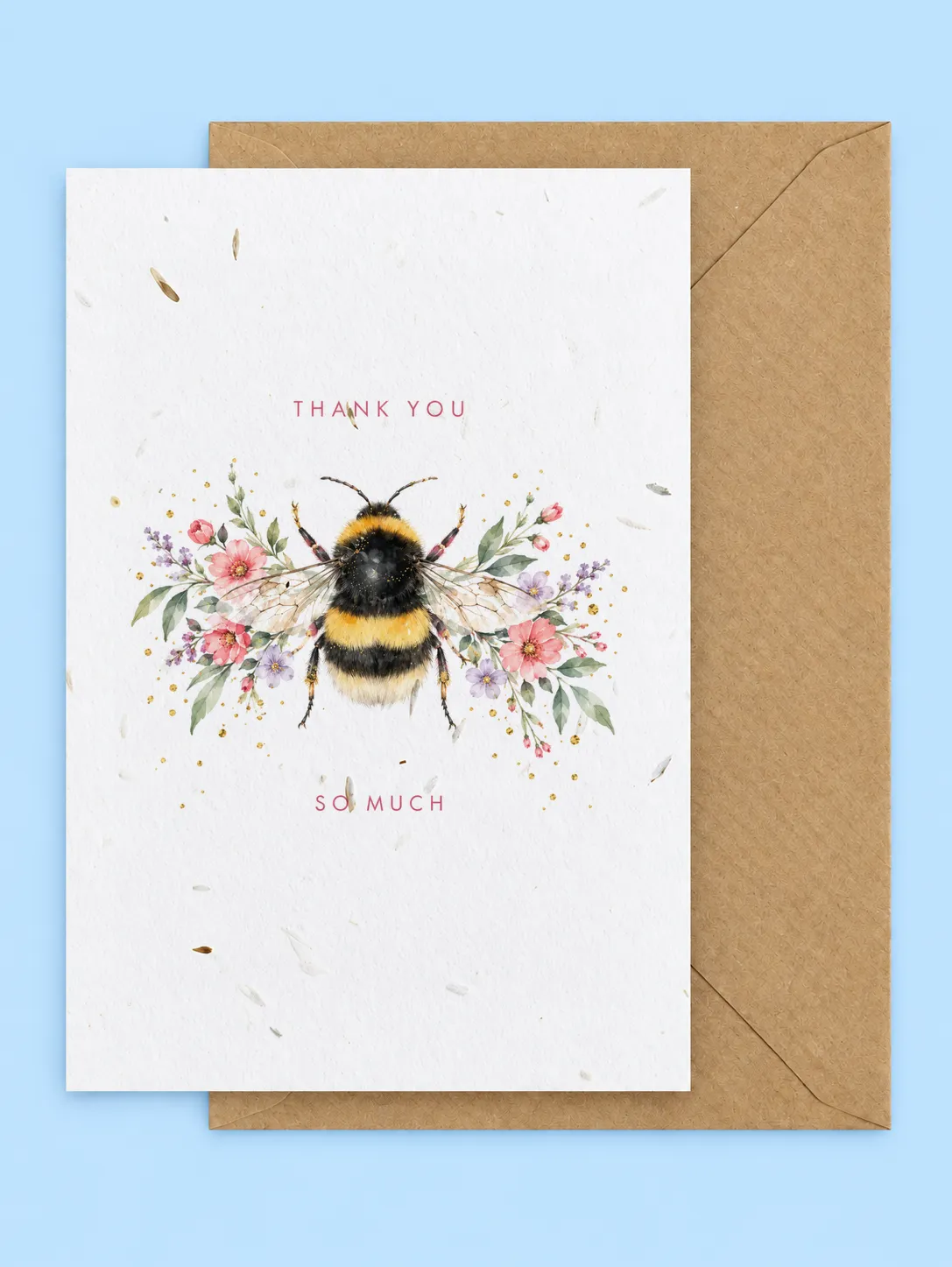 Bumblebee between sprays of pink and lilac wildflowers with Thank you so much lettering, seed-filled thank you card with a kraft envelope on a pale blue background