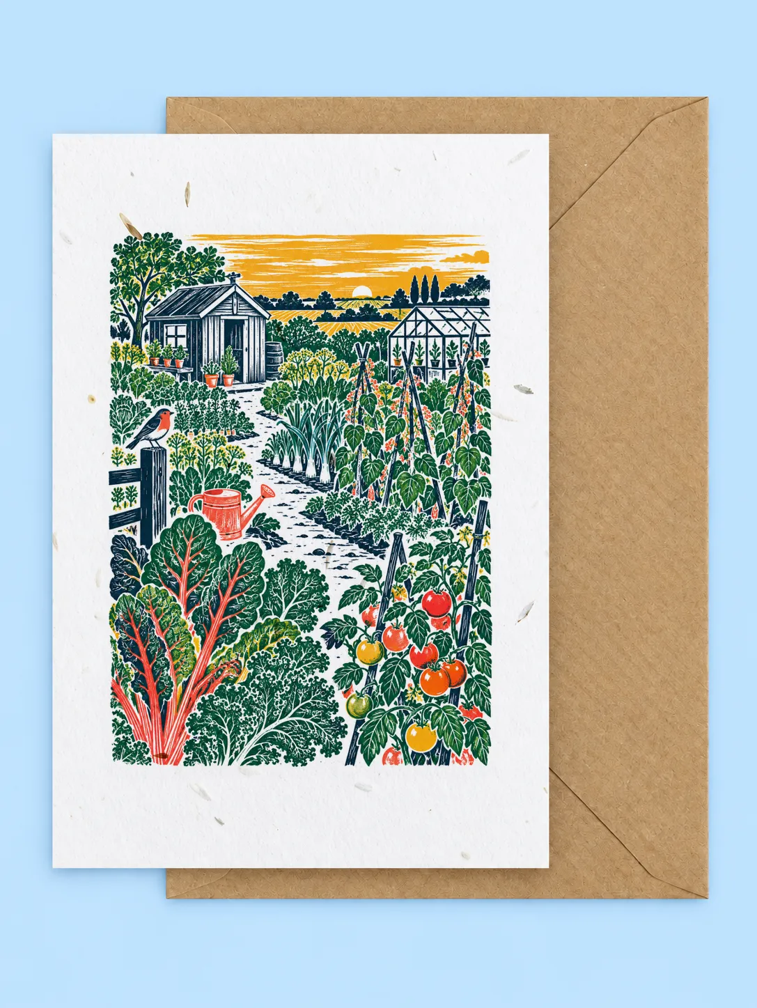 Linocut style allotment with a shed, greenhouse, chard, tomatoes and a robin under a yellow sky, plantable greetings card with a kraft envelope on a pale blue background