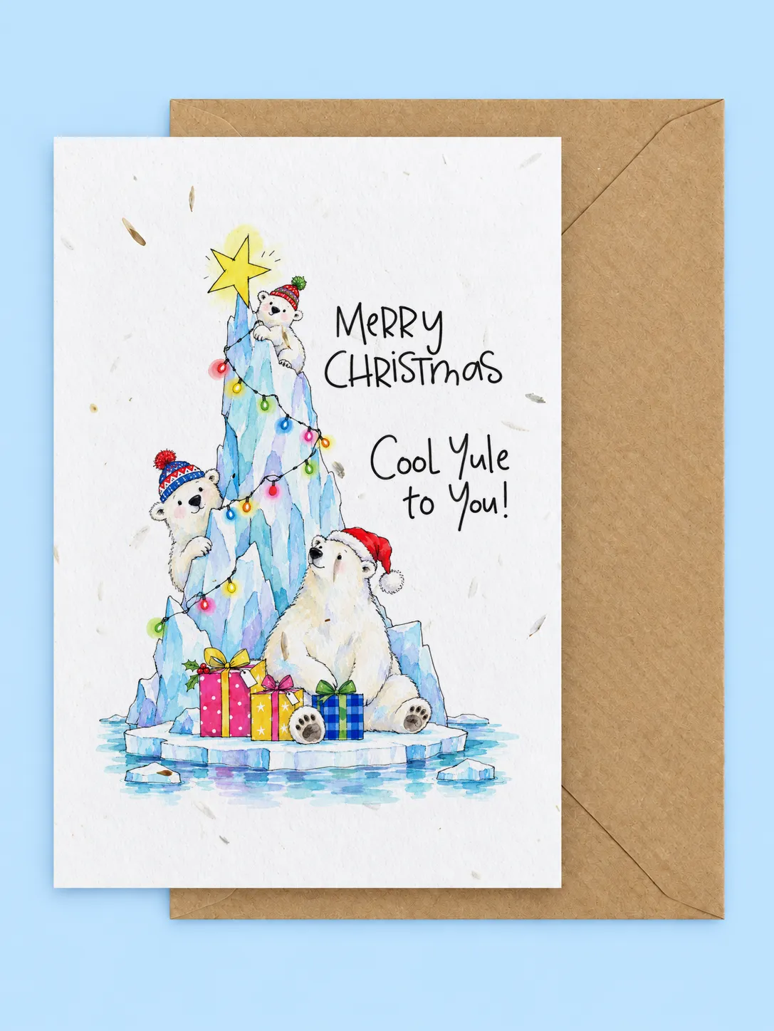 Polar bears on an icy Christmas tree with fairy lights, a star and presents, Cool Yule to You seed paper Christmas card with a kraft envelope on a pale blue background